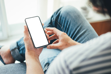 Mockup image blank white screen cell phone.man hand holding texting using mobile sitting at coffee shop.background empty space for advertise text.people contact marketing business,technology 