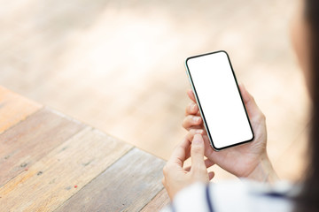 Mockup image blank white screen cell phone.man hand holding texting using mobile sitting at coffee shop.background empty space for advertise text.people contact marketing business,technology 