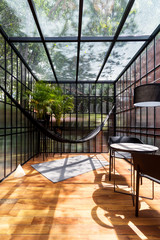 Modern sunroom with a hammock and some plants - obrazy, fototapety, plakaty