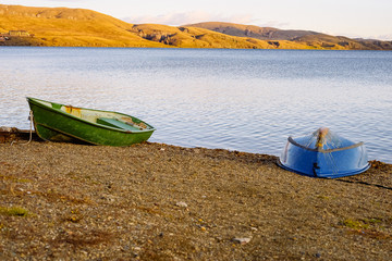 Two boats with oars at the beginning of autumn are empty at the pier on the lake. Lake and boat concept