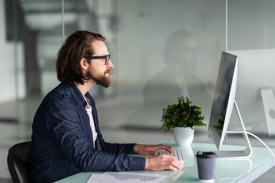 Bearded businessman working with computer in office
