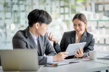 Fototapeta premium Group of modern business people are talking and smiling at the meeting. Asian business groups discussed investment and business planning at the meeting.
