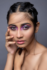 Fototapeta na wymiar Closeup portrait of an Indian model with bold eye makeup and lipstick looking at camera. Makeup portrait for eye makeup and lipstick.