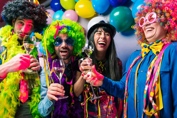 Obraz premium Happy girls and boys at Carnival Party clinking glasses with champagne.