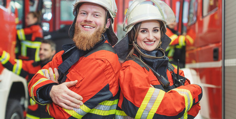 Fire fighter man and woman standing shoulder to shoulder