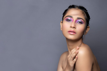 Closeup portrait of an Indian model with bold eye makeup and lipstick looking at camera. Makeup...