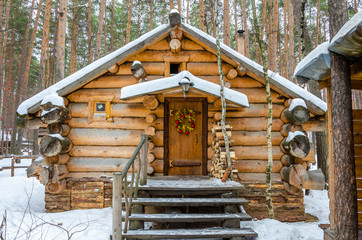 Log house in the winter in the forest.Wooden structure for relaxing among the trees. - Powered by Adobe