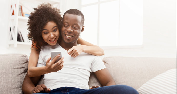 Cheerful african couple shopping online on cellphone