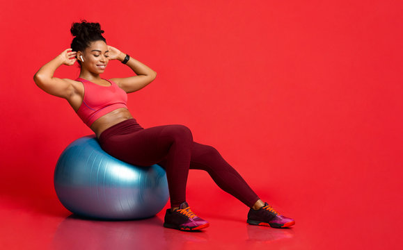 Young sporty black girl working out with fitness ball