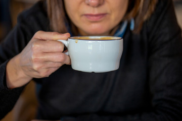 Mujer desayunando café con leche