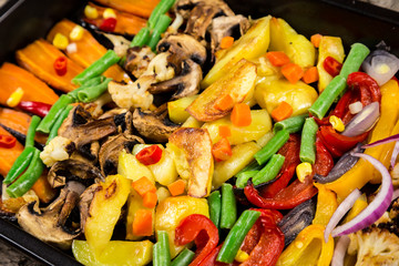Chopped stewed vegetables on tray, food background, closeup