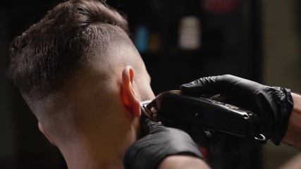 Handsome man getting new hairstyle with electric trimmer