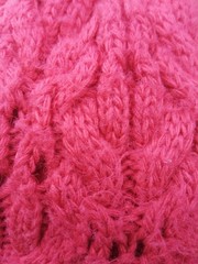 Pink background with knitted threads.
