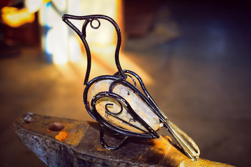 Bird made of iron and stone. The product, handmade by a blacksmith.