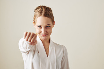 Successful Caucasian woman giving fist bump looking at camera horizontal srudio portrait