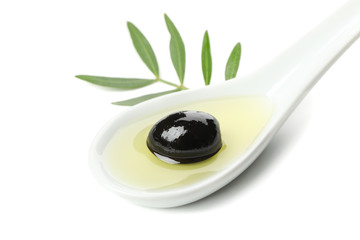 Ceramic spoon with olive oil, olive and leaves isolated on white background