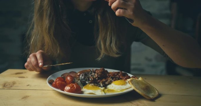 Young woman eating traditional english breakfast