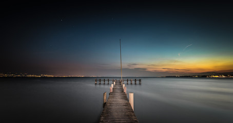 Landing stage photographed at night, facing the lake and the landscape at night, sunset and night light