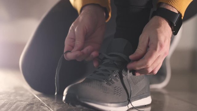 Jogger tying sneaker shoelaces before running