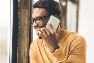 Cheerful black guy talking on the phone