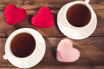 two cups of tea, hearts, top view on a rustic background. Valentine's Day