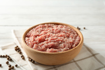 Fototapeta na wymiar Towel, spices and bowl with minced meat on wooden background, close up