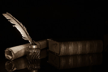 Quill pen and rolled up papyrus sheets with old books, sepia effect