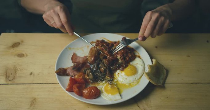 Young woman eating traditional english breakfast