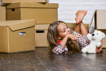 Fototapeta premium Lease a lifestyle makeover. happy child cardboard box. Moving concept. new apartment. purchase of new habitation. Cardboard boxes - moving to new house. happy little girl with toy