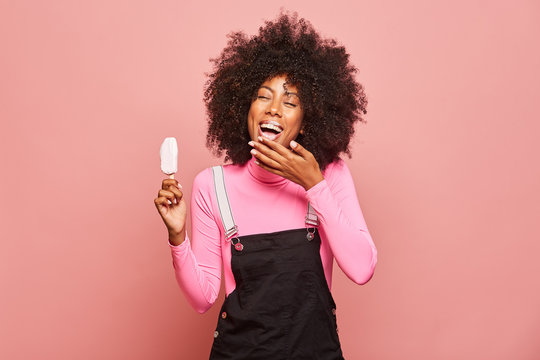 Funny woman with ice cream on stick looking at camera