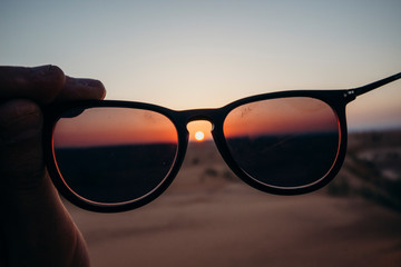 Sunset behind glasses, desert and perspective, point of view