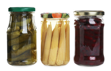 Glass jars of different pickled vegetables isolated on white
