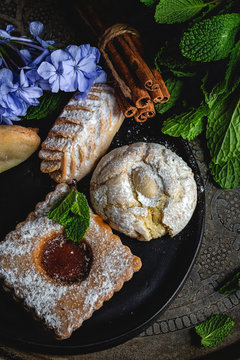 Traditional tea with mint and assorted homedade Arab sweets on dark background. Ramadan. Islamic. Halal