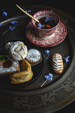 Traditional tea with mint and assorted homedade Arab sweets on dark background. Ramadan. Islamic. Halal