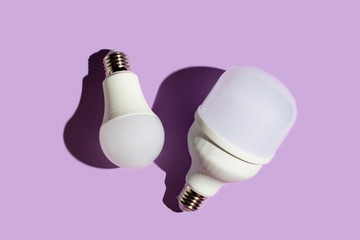 two led light bulbs with hard shadows on a purple background