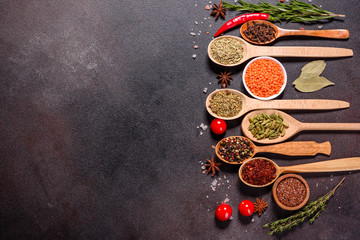 A set of spices and herbs. Indian cuisine. Pepper, salt, paprika, basil and other on a dark...
