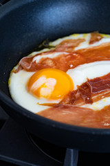 Fried Eggs with Prosciutto in Pan for Breakfast. Ready to Eat.