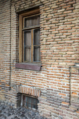 Fototapeta na wymiar An old brick house with wooden windows