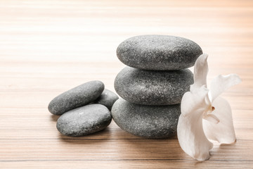Stones and orchid flower on wooden background. Zen lifestyle