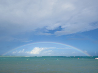 Rainbow over Caribbean sea with turquoise waters and blue sky with white clouds. Tropical landscape