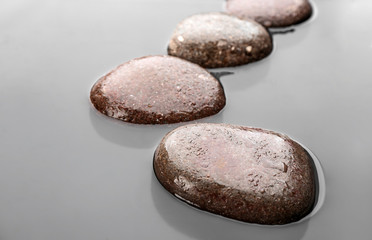 Fototapeta na wymiar Wet stones in water, closeup. Zen lifestyle