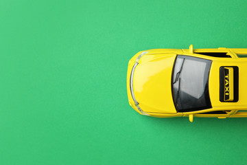 Yellow taxi car model on green background, top view. Space for text
