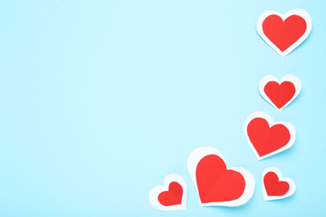 Red and white paper hearts on blue background
