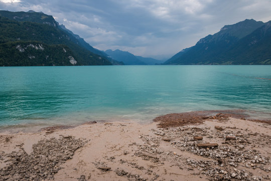 Breathtaking landscape of tranquil calm water ans stony shore surrounded by rocky mountains in Switzerland 