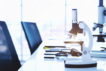 Microscope and test tubes with lab glassware in laboratory background, research and Scientific concept