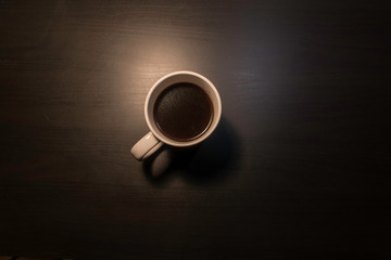 Black coffee in cup with soft shadow on plain background with space for text