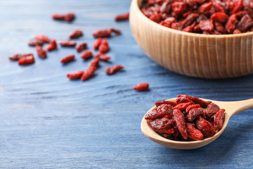 Dry goji berries on blue wooden table, closeup