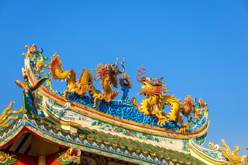 Beautiful Elegant double golden dragon statue on the roof of on a temple for Chinese New Year...