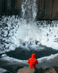 Fototapeta premium chico mirando cascada con abrigo rojo