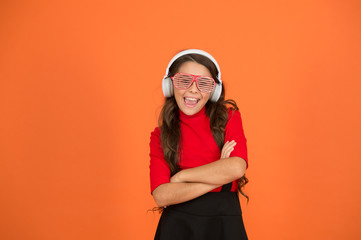 Party accessory. Girl with eyeglasses orange background. Event and entertainment. Party girl. Having fun. Play list for party. Music concept. Kid wear eyeglasses. Eyewear fashion store. Cool track